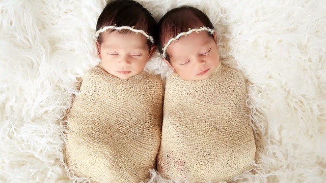 This mother places her twin daughters side by side so she can capture some unforgettable moments